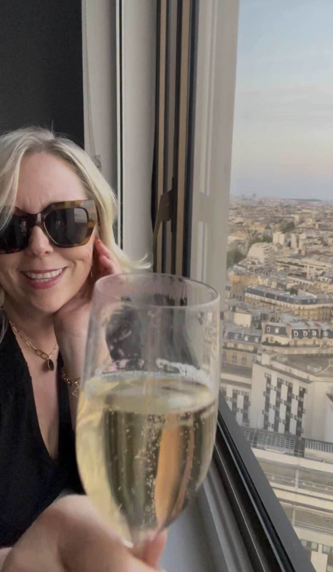 Rosanne in Paris with her mom, toasting with champagne in front of the city rooftops